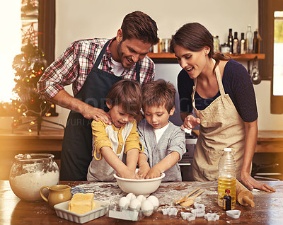 Buy stock photo Cropped shot of two young brothers baking with their parents in the kitchen