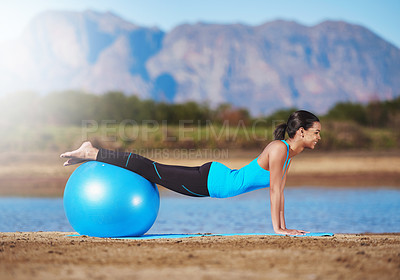 Buy stock photo Shot of a young woman working out with an exercise ball
