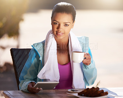 Buy stock photo Cropped shot of a young woman grabbing snack while using her digital tablet after her workout
