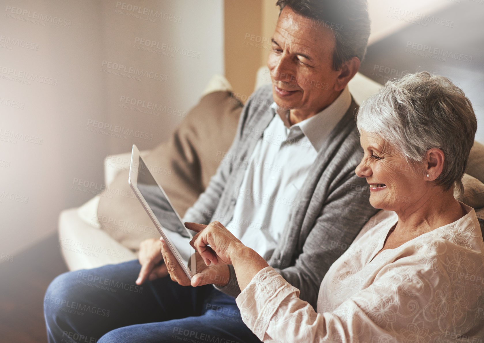 Buy stock photo Tablet, relax or old couple streaming film or movies on online subscription in retirement at home together. Love, pointing or senior woman watching videos with a happy elderly man in living room sofa