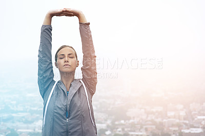 Buy stock photo Shot of a young woman stretching before a morning run