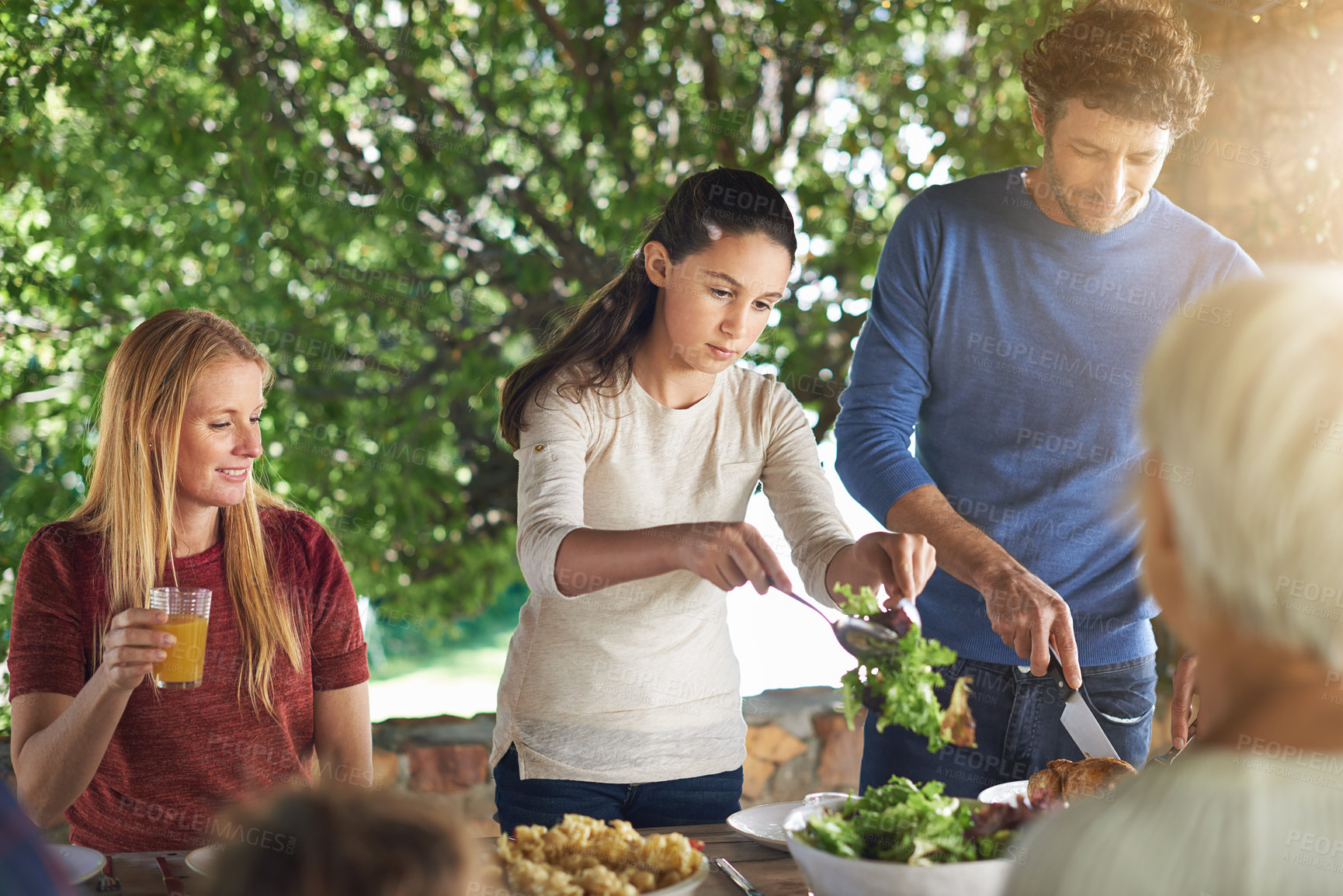 Buy stock photo Food, salad and help with family at lunch in nature for health, bonding and celebration. Vacation, barbecue and event with parents and children eating together for garden, generations and wellness