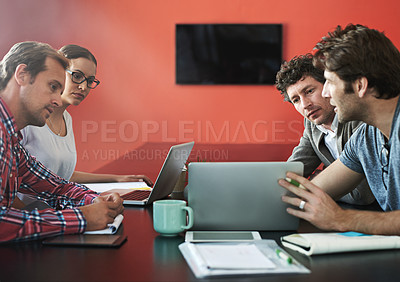 Buy stock photo Shot of coworkers talking together over a laptop in an office