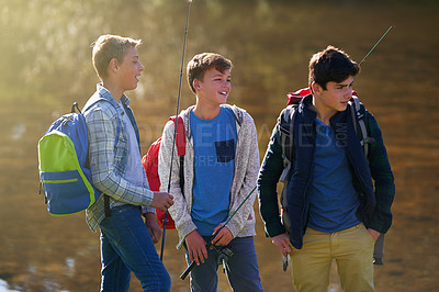 Buy stock photo Shot of a group of young boys fishing by a lake