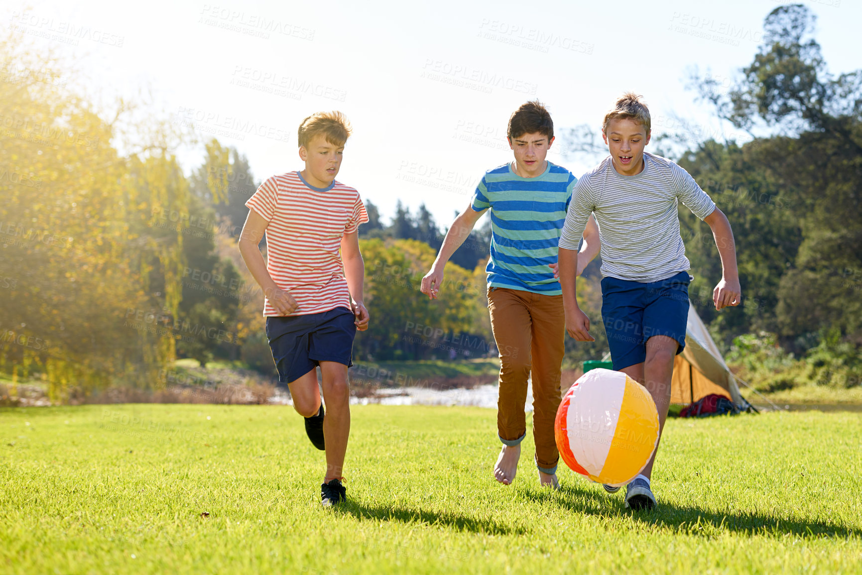 Buy stock photo Shot of a group of teenage boys playing with a ball outdoors