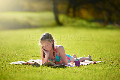 Buy stock photo Girl, book or reading to relax, grass or imagine by story, freedom or vacation at summer camp. Tween, novel or fiction as thinking to wonder of idea, dream or fantasy by lying on ground in nature