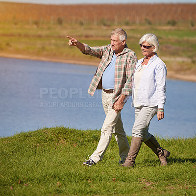 Buy stock photo Shot of a happy senior couple going for a walk at the lake