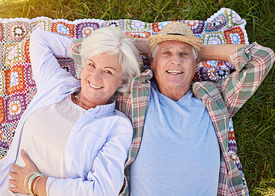 Buy stock photo Portrait, picnic and an elderly couple lying on a blanket in a field together for romance or bonding from above. Relax, smile and retirement with happy seniors outdoor in the countryside for dating