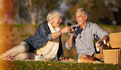 Buy stock photo Senior couple, happy and toasting wine glasses for picnic date, sundowners or lunch by the lake. Elderly man, relaxed and mature woman smiling for retirement, relationship celebration or bonding 