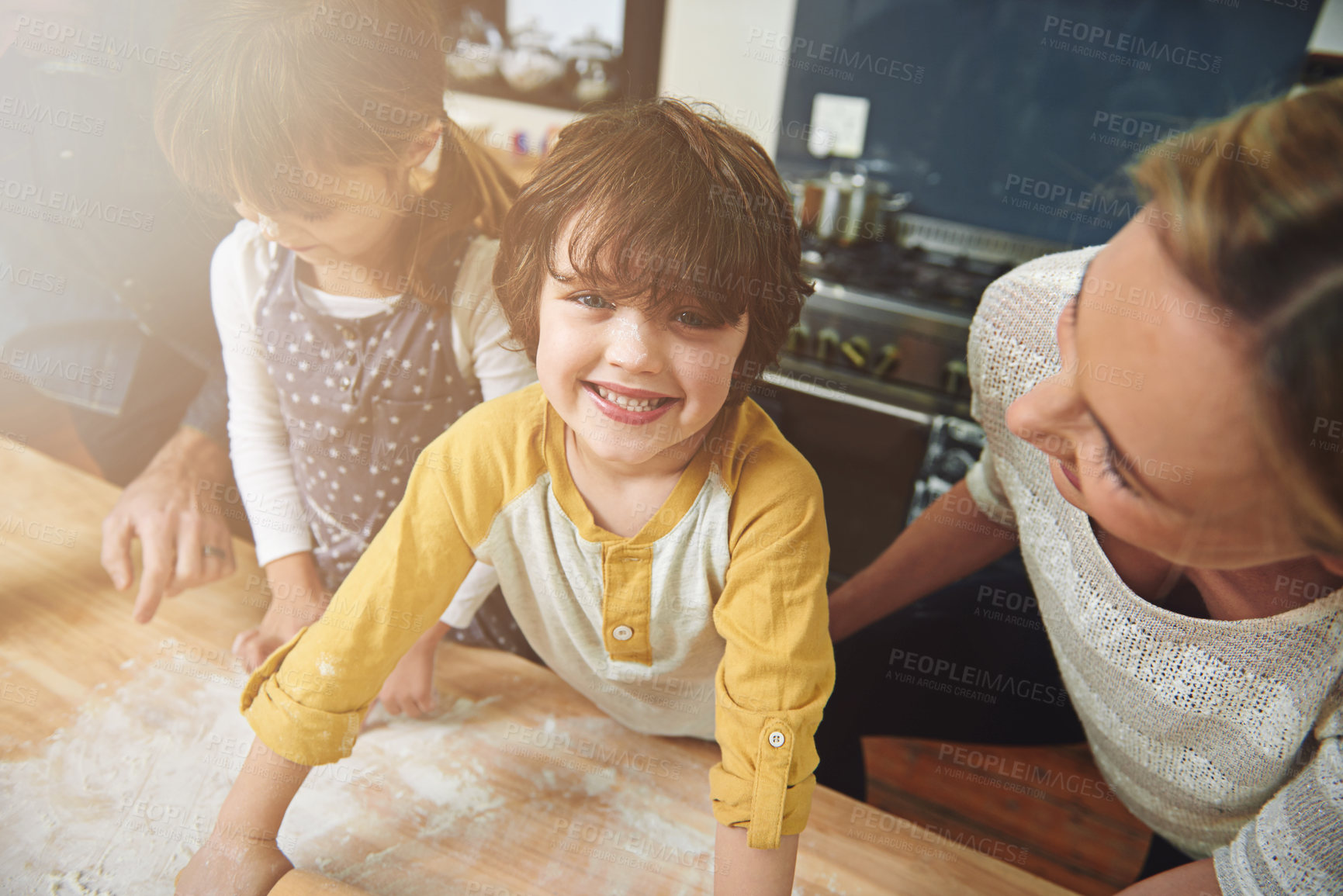Buy stock photo Portrait, kid and happy family baking food in kitchen together, preparation and learning in home. Face, mother and father with children cooking, teaching and help parents with flour dough at table