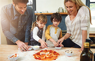 Buy stock photo Parents, children and cooking pizza in kitchen with cheese, learning and helping hand for development in home. Mother, father and kids with dough, teaching and support with bonding in family house
