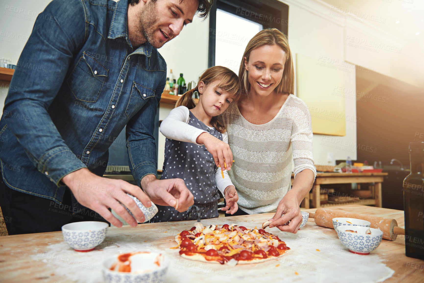Buy stock photo Learning, smile and family baking pizza in kitchen together, bonding and happy in home. Food, mother and father with kid cooking, teaching and help parents prepare for lunch with cheese at table