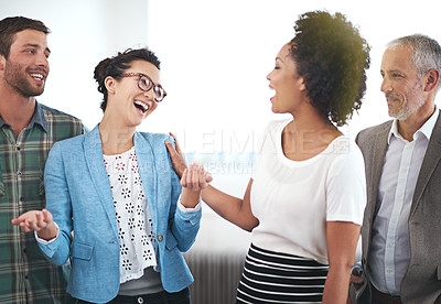 Buy stock photo Shot of a group of laughing coworkers standing in an office