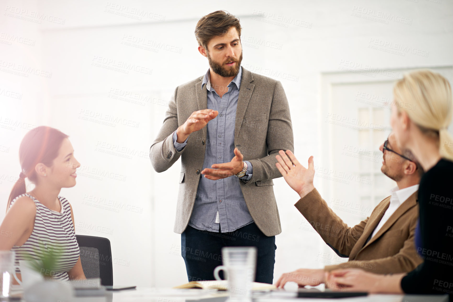 Buy stock photo A businessman explaining something to his colleagues in a meeting