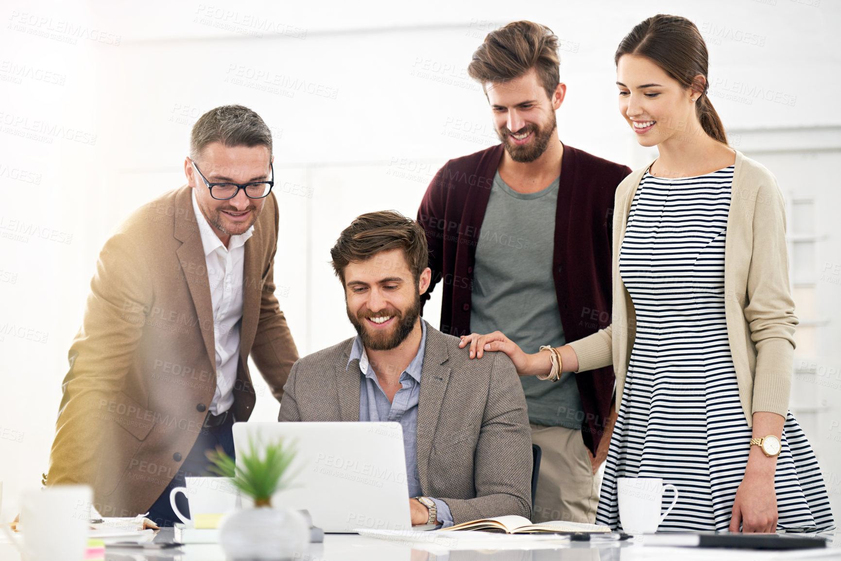 Buy stock photo Shot of businesspeople working together at a laptop