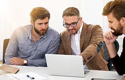 Buy stock photo Shot of businesspeople working together at a laptop