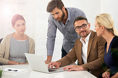 Buy stock photo A group of businesspeople looking at work on a laptop in a meeting
