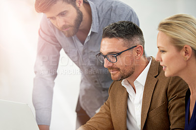 Buy stock photo A group of businesspeople working together at a laptop