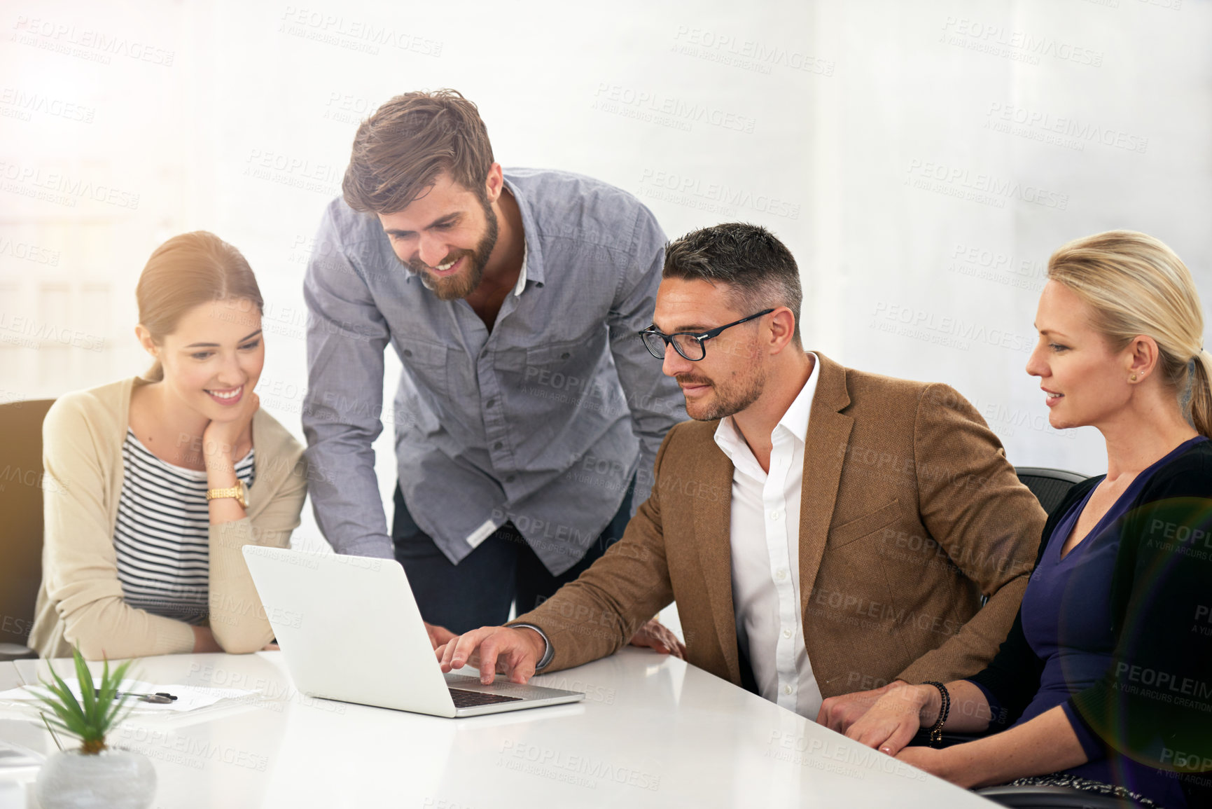 Buy stock photo A group of businesspeople looking at work on a laptop in a meeting