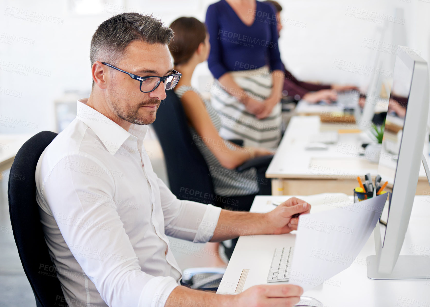 Buy stock photo Businessman, paper and reading with computer in office for campaign planning, update media listing and report. Public relations employee, online and working on technology for research market trends.