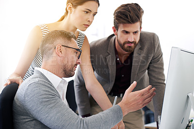 Buy stock photo Shot of a group of designers working together at a computer