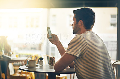 Buy stock photo Young man, typing and reading with phone at cafe in social media, communication or networking at indoor restaurant. Male person on mobile smartphone for online chatting, texting or app at coffee shop