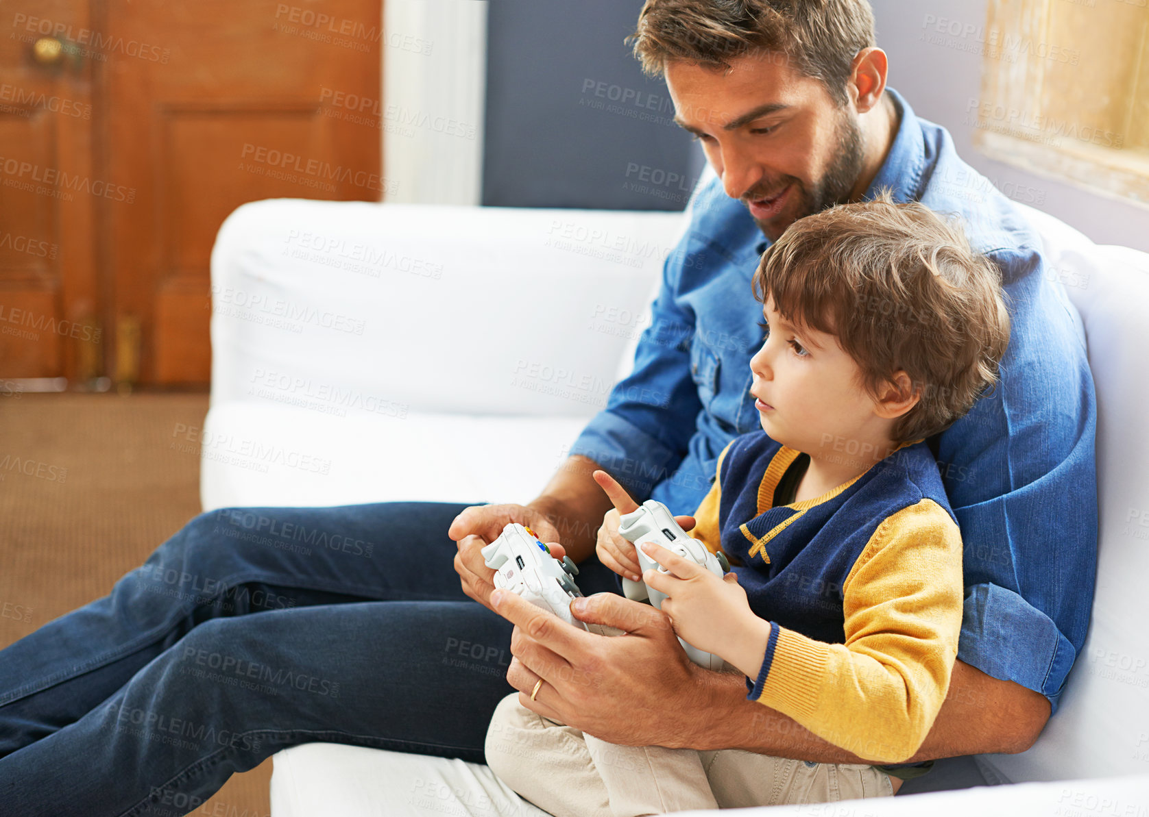Buy stock photo Gaming, dad and son on a sofa, playful and bonding with fun, happiness and chilling at home. Family, father and boy with parent, male child and kid with controller, video games and multi player app