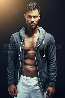 Buy stock photo Fitness, portrait and man in studio with stomach muscle, confidence and workout routine in health, wellness and power. Hoodie, pride and strong athlete on black background for exercise, body and care