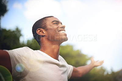 Buy stock photo Shot of a man standing outside with his arms outstretched in delight