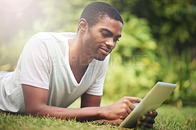 Buy stock photo Relax, happy and tablet with black man on grass of garden for research or information in summer. Technology, internet and young person reading online ebook on green field outdoor in backyard