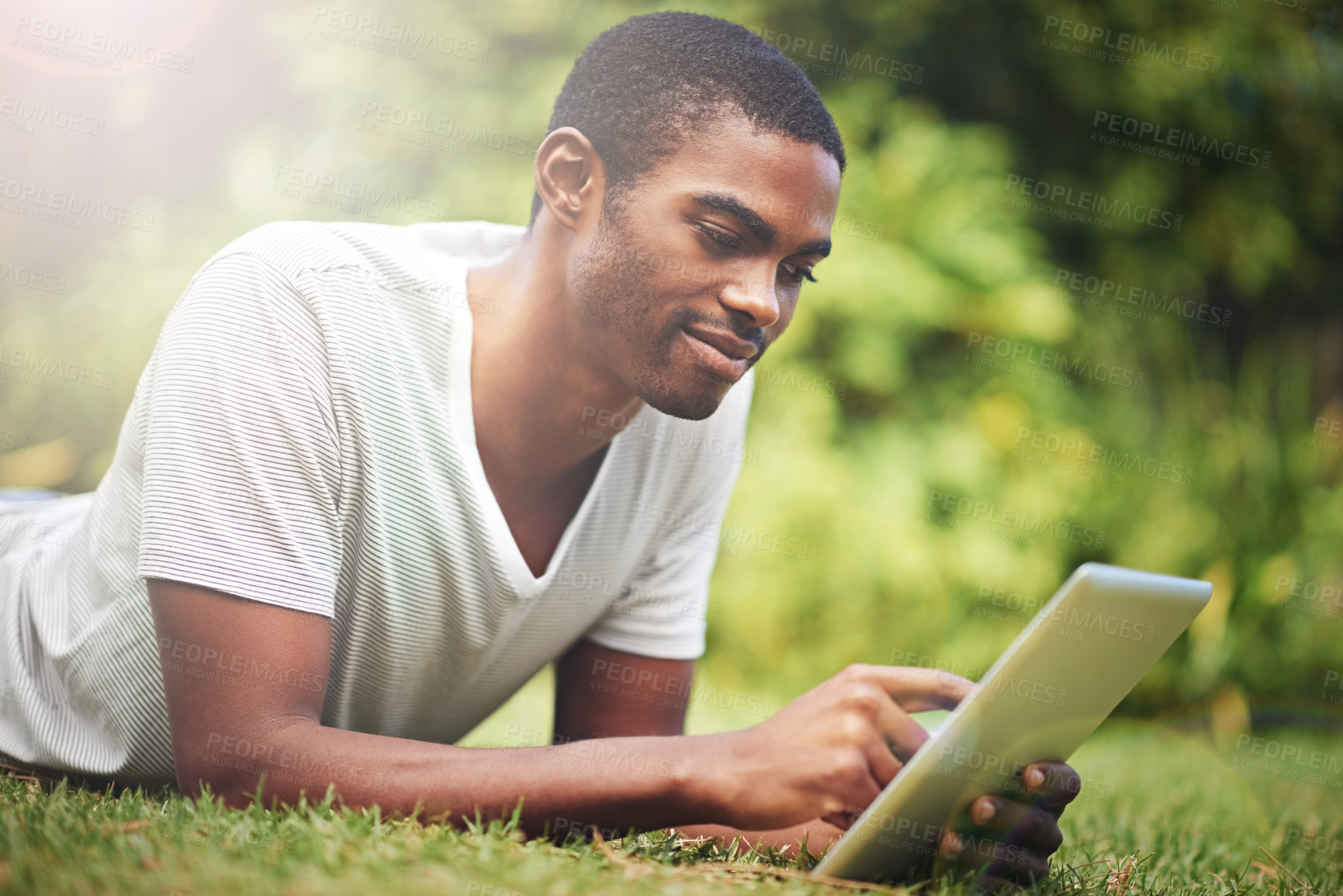 Buy stock photo Relax, happy and tablet with black man on grass of garden for research or information in summer. Technology, internet and young person reading online ebook on green field outdoor in backyard