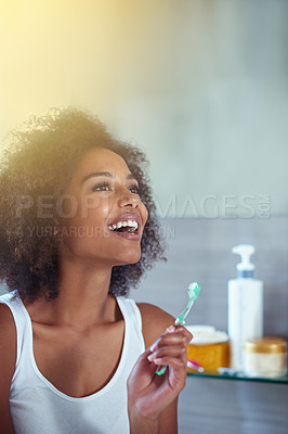 Buy stock photo Cropped shot of a young woman brushing her teeth in the bathroom