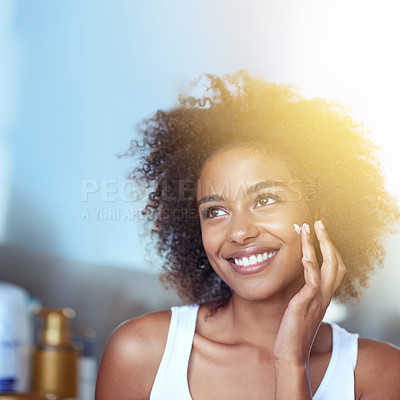 Buy stock photo Cropped shot of a young woman moisturizing her face in the bathroom