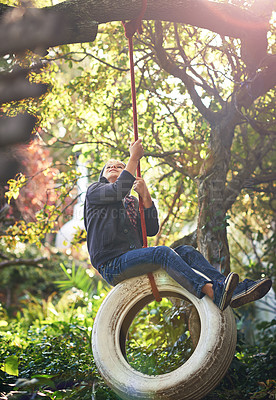 Buy stock photo Boy, tyre swing and playing in garden with happiness, recreation or countryside vacation in summer. Child, excited and diy adventure playground in backyard of home with sunlight and trees in nature