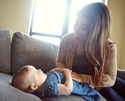 Buy stock photo Mom, bonding or laughing baby girl in house living room or family home sofa in goofy, comic or funny tickle game. Smile, infant and happy mother playing with child after changing diapers on furniture