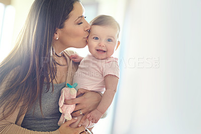 Buy stock photo Mother, bonding and forehead kiss for baby girl on in house living room, nursery or family home bedroom in trust or love. Smile, happy and infant child with mom in support, security or safety comfort
