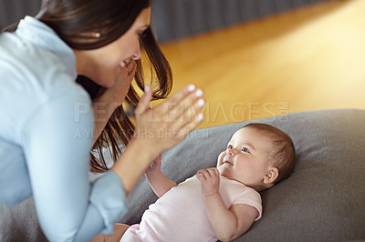 Buy stock photo Shot of a mother playing with her baby girl at home