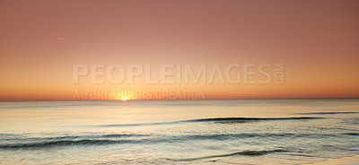 Buy stock photo Seascape and landscape of a beautiful orange sunset on the west coast of Jutland in Loekken, Denmark. Sun setting on the horizon on an empty beach at dusk over the ocean and sea at night 