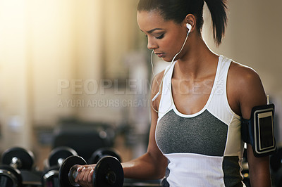 Buy stock photo Fitness, music and dumbbell with a woman in the gym, streaming audio through earphones while training. Exercise, workout and weightlifting with a female bodybuilder in a sports club for health