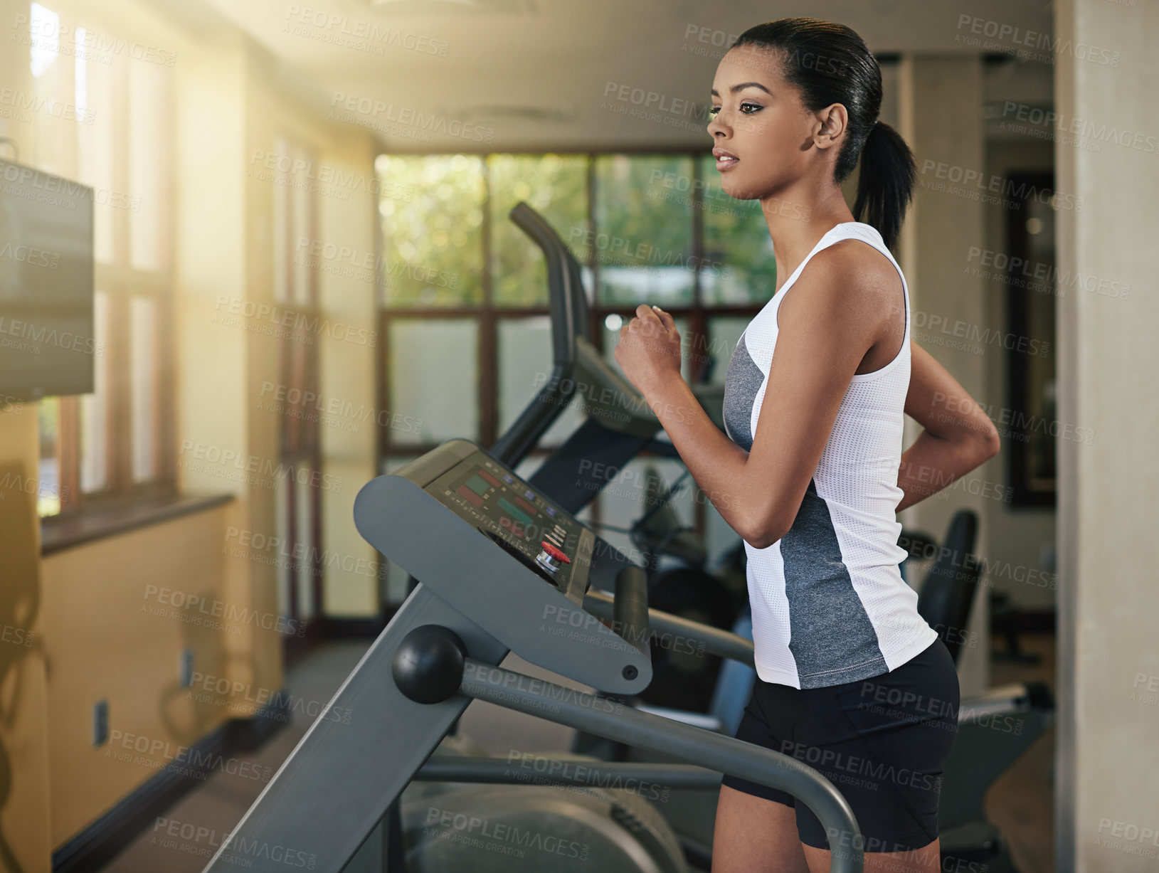 Buy stock photo Shot of a young woman exercising on a treadmill at the gym