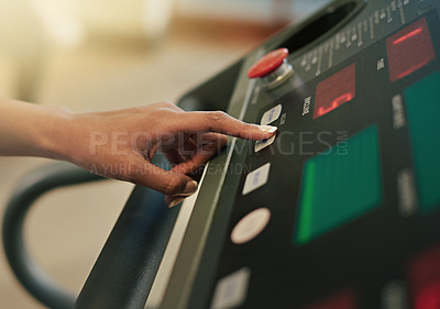 Buy stock photo Shot of a woman adjusting the controls on a treadmill