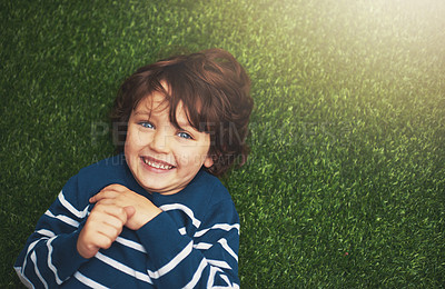 Buy stock photo Happy, youth and portrait of boy on grass for relax, playful fun and happiness in garden. Family, nature and above of kid for childhood, playing and freedom on weekend, vacation or holiday outdoors 