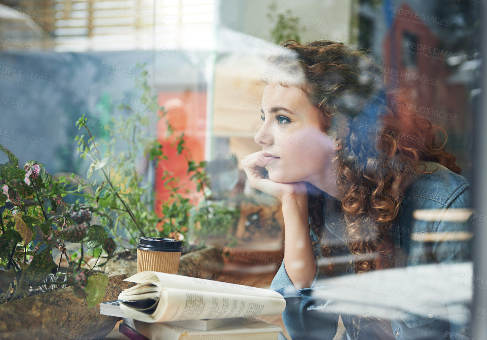 Buy stock photo A young woman looking thoughtful while reading a book in a coffee shop