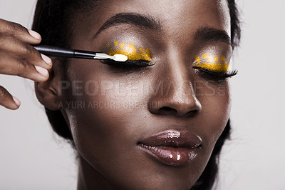 Buy stock photo Studio shot of a beautiful young woman applying eye makeup