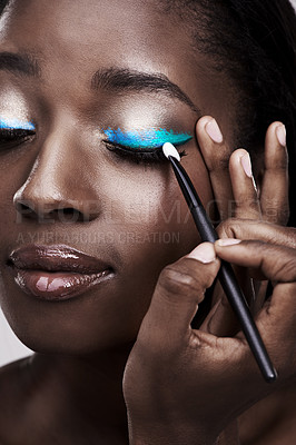 Buy stock photo Brush, makeup and face of black woman with cosmetics for wellness, beauty and model. Cosmetology, skincare and person with tools for makeover application, blue eyeshadow and products in studio