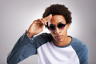 Buy stock photo Portrait, man and fashion with sunglasses in studio for designer casual sweater style for design of creative marketing appreciation. Hipster, person and saluting in natural clothes on grey background