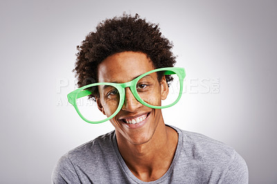 Buy stock photo Portrait, black man or glasses as funny, joke or vision of comic, customer or service in studio. Plastic eyewear, male person or smile at goofy, visual or humor of ophthalmology on grey background