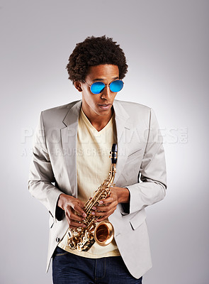 Buy stock photo Man, fashion and jazz with saxophone in studio from trendy sunglasses with instrument as musician. Confident, male person and stylish performer play melody, tune and for musical entertainment