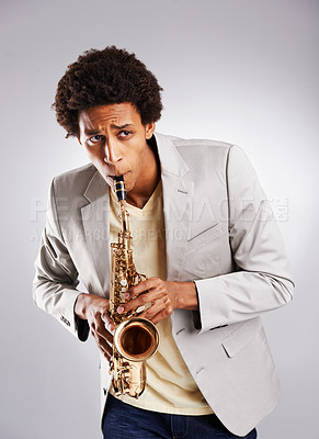 Buy stock photo Happy, african man and music, playing the saxophone with casual outfit and clothing in studio. Confident  musician, jazz and instrument with trendy suit for band performance on white background