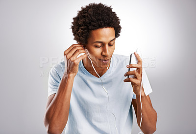 Buy stock photo Black man, listening to music and cellphone with sound, radio and live streaming on a white studio background. African person, guy and model with smartphone and connection with digital app and audio